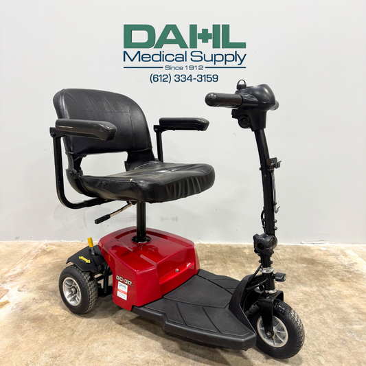 Angled view of a used Pride Go-Go ES 3-wheel mobility scooter showing the front tiller, padded seat, and stable three-wheel design, displayed at Dahl Medical Supply.