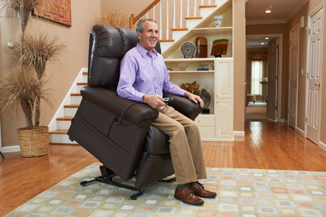 Man sitting in a brown power lift chair using a handheld remote to rise to a standing position, demonstrating lift chair comfort and support from Dahl Medical Supply.