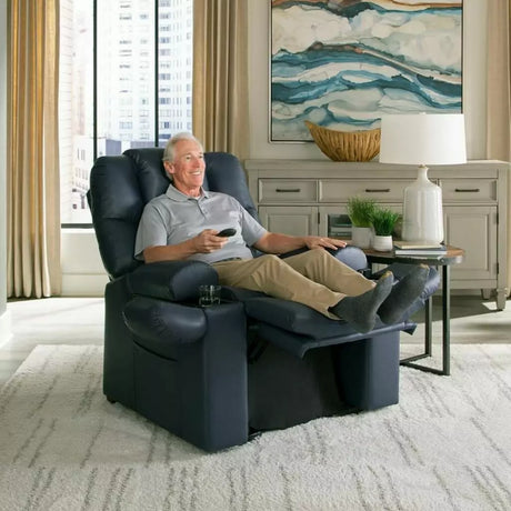 Man relaxing in a navy infinite-position lift chair from Dahl Medical Supply, reclining with feet elevated and remote in hand for customizable comfort and support.