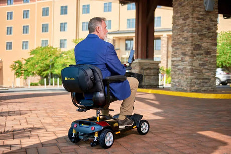 Man riding a Golden mobility scooter outside a Minnesota hotel, demonstrating reliable power mobility and comfort—available at Dahl Medical Supply in Burnsville, MN, serving the Twin Cities area.