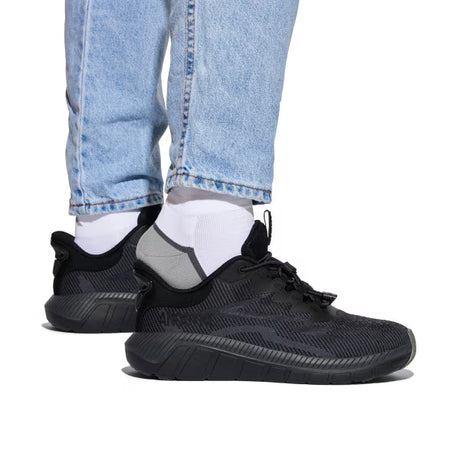 Person wearing black Anodyne No. 48 Sport Dash diabetic sneakers with white socks and light blue jeans, showcasing the comfortable step-in design and supportive fit.