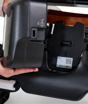 Close-up of the Golden Ally GP303 portable power wheelchair showing the removable battery being lifted from the frame, highlighting easy-access locking and release mechanism.