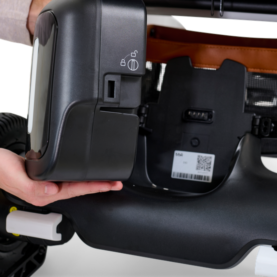 Close-up of the Golden Ally GP303 portable power wheelchair showing the removable battery being lifted from the frame, highlighting easy-access locking and release mechanism.