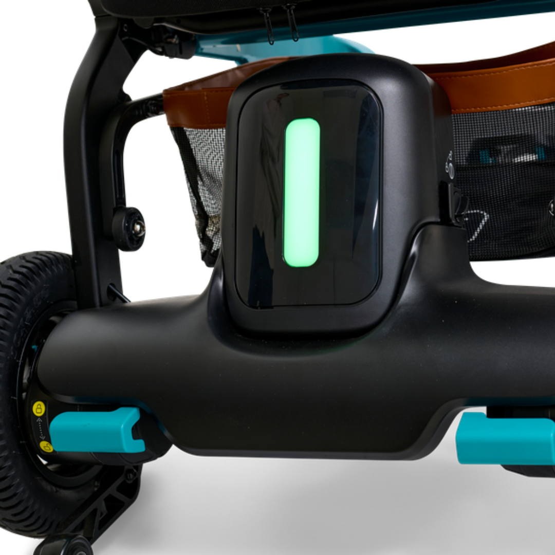 Close-up view of the Golden Ally GP303 power wheelchair showing the illuminated rear light indicator, teal accents, and durable rear wheel assembly.