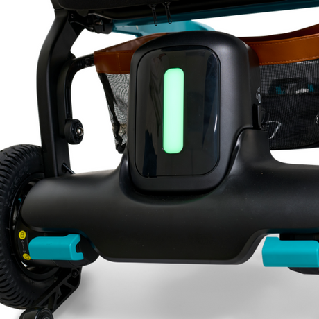 Close-up view of the Golden Ally GP303 power wheelchair showing the illuminated rear light indicator, teal accents, and durable rear wheel assembly.