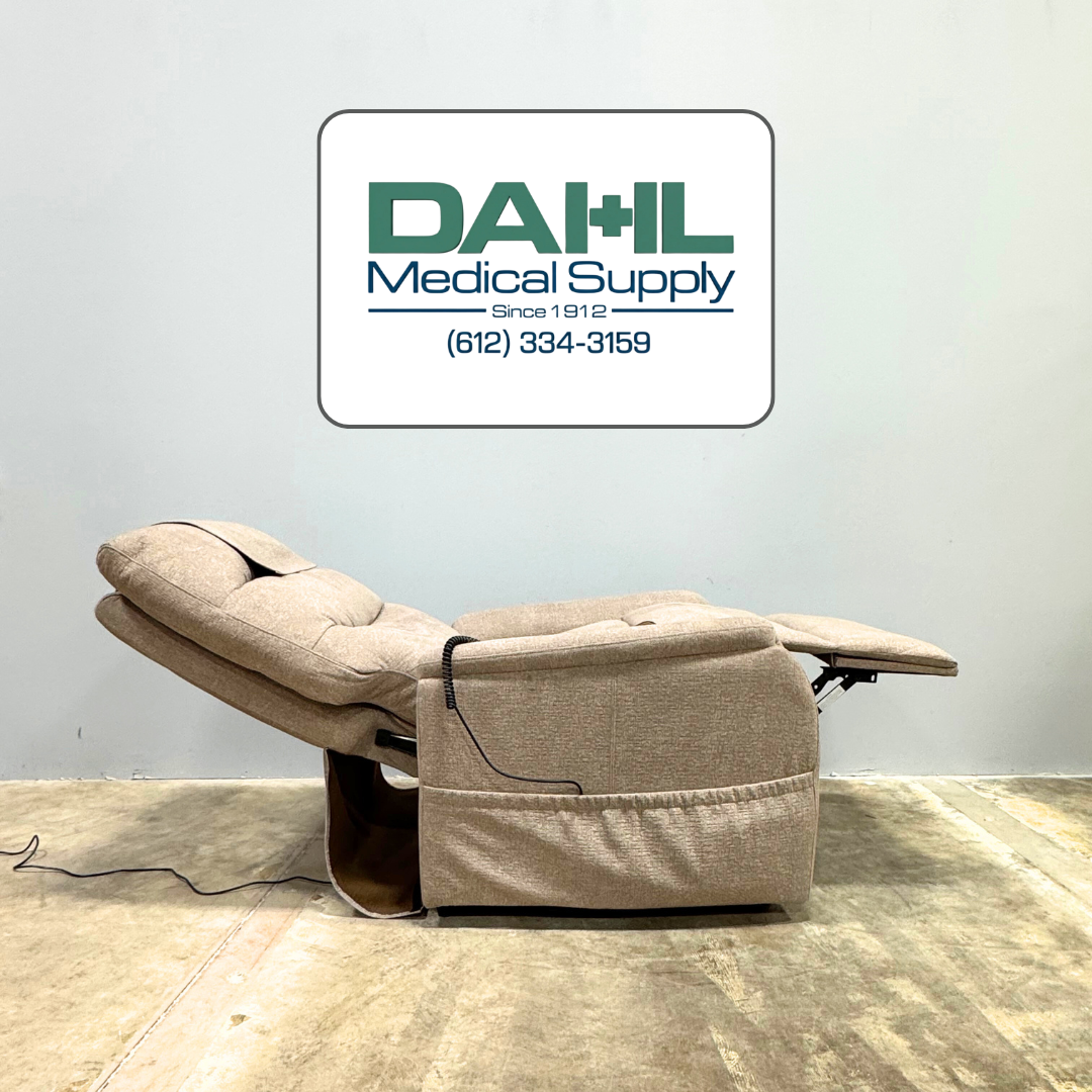 Very lightly used Golden PR118 lift chair shown in a reclined resting position, featuring supportive cushioning, extended footrest, and neutral fabric. Photo taken at Dahl Medical Supply showroom in Minnesota.