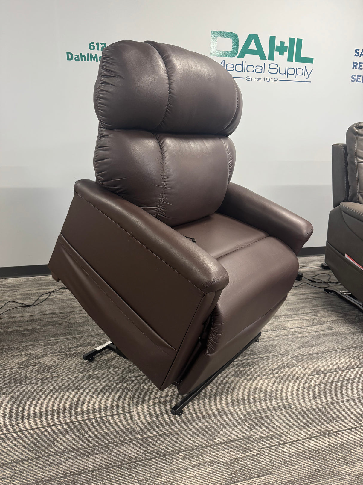 Golden Technologies PR531-T28 Tall/Wide Lift Chair in rich Coffee Bean upholstery displayed in the Dahl Medical Supply showroom, featuring plush overstuffed cushions and full lift position for tall and broad users.