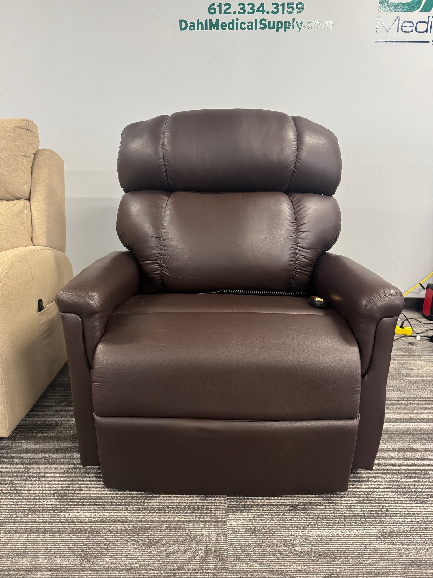 Front view of the Golden Technologies PR531-T28 Tall/Wide Lift Chair in Coffee Bean color, displayed in the Dahl Medical Supply showroom. The plush overstuffed backrest and wide seat design highlight its comfort and durability for tall and broad users.
