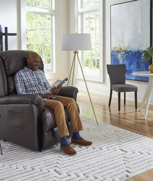 Person seated in a Golden PR766 EZ Sleeper Lift Chair with Twilight positioning in dark brown fabric