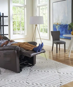 Person relaxing in a Golden PR766 EZ Sleeper Lift Chair with Twilight positioning