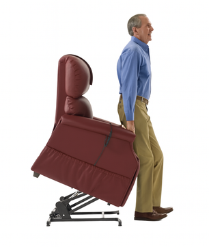 Man using a red reclining lift chair that tilts forward to assist him in standing, showing the safety and comfort features available with Dahl Medical Supply’s lift chair rentals.