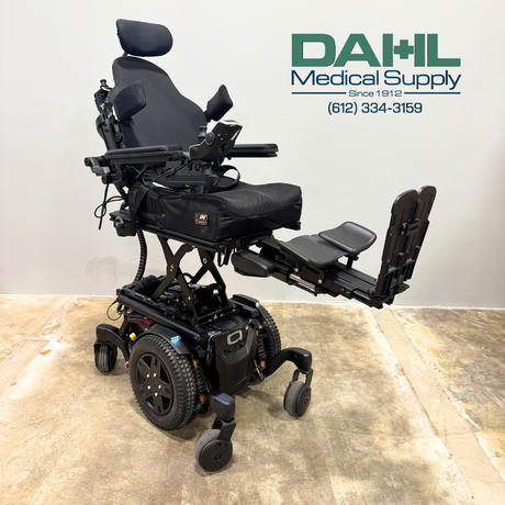 Angled view of a used Pride Edge® 3 Stretto iLevel power wheelchair in the raised position, highlighting the power elevation feature, seating system, and stable mid-wheel drive base.