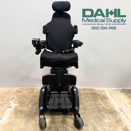 Front view of a used Pride Edge® 3 Stretto iLevel power wheelchair showing the supportive seating, foot platform, joystick control, and narrow stance for indoor maneuverability.