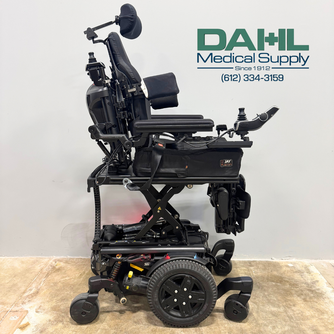Side profile of a used Pride Edge® 3 Stretto iLevel power wheelchair displaying the iLevel lift system, mid-wheel drive suspension, armrests, and contoured seating.