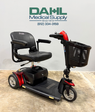 Angled front view of a used Pride Go Go Elite Traveller Plus 3-wheel mobility scooter featuring a padded seat, front basket, and easy-to-use tiller controls.