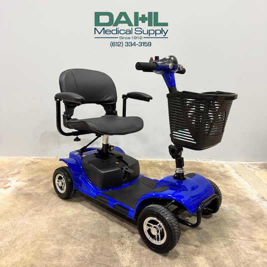Front angled view of a used Vive 4-wheel mobility scooter showing the adjustable seat, tiller controls, front basket, and wide tires, displayed at Dahl Medical Supply.