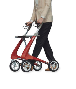 Person walking with the byACRE Ultralight Carbon Fiber Rollator in red, demonstrating lightweight mobility support, available at Dahl Medical Supply.